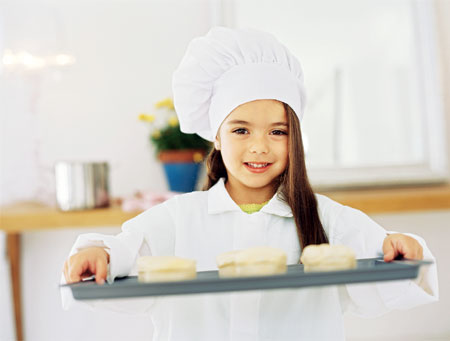 Enfant cuisinière avec pâtisserie 